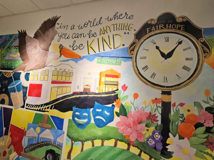 Mural with the Fairhope clock, pelican, and be kind statement