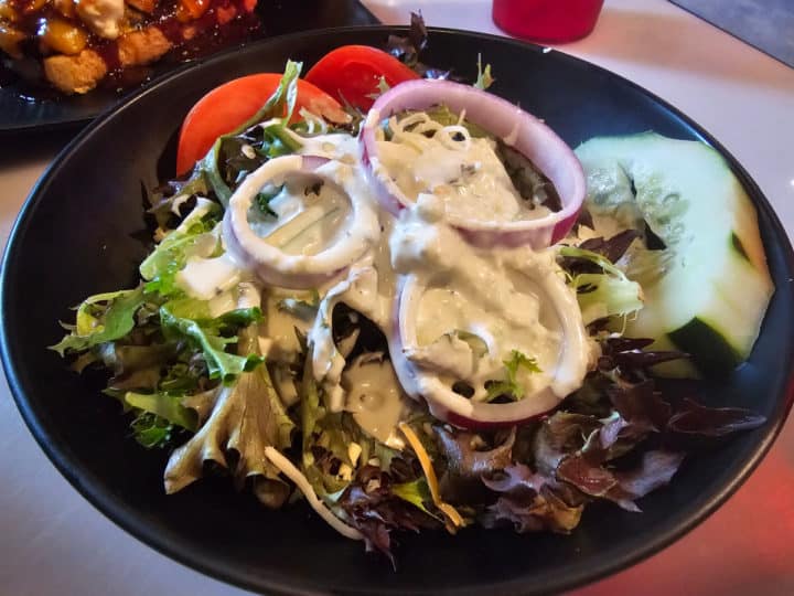 House salad with ranch on a black plate