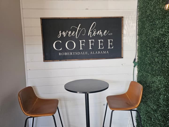 Sweet Home Coffee sign over two stools and a table