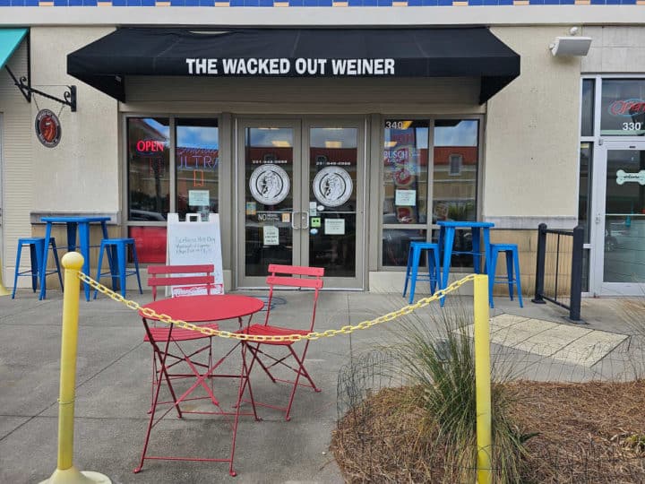 outdoor tables and chairs in front of the entrance to Wacked out Weiner