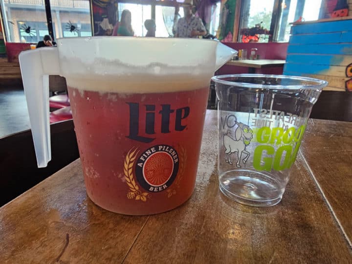Pitcher of Beer next to a plastic glass