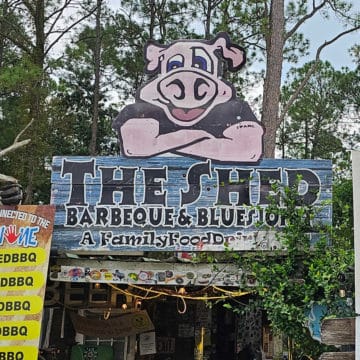 The Shed BBQ sign with a pink pig over the top of it