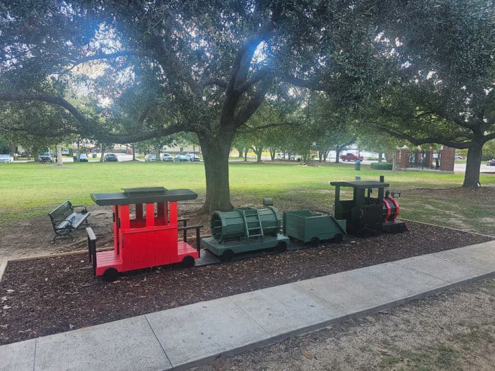 small train for kids to climb on with a locomotive, freight cars, and a caboose. 