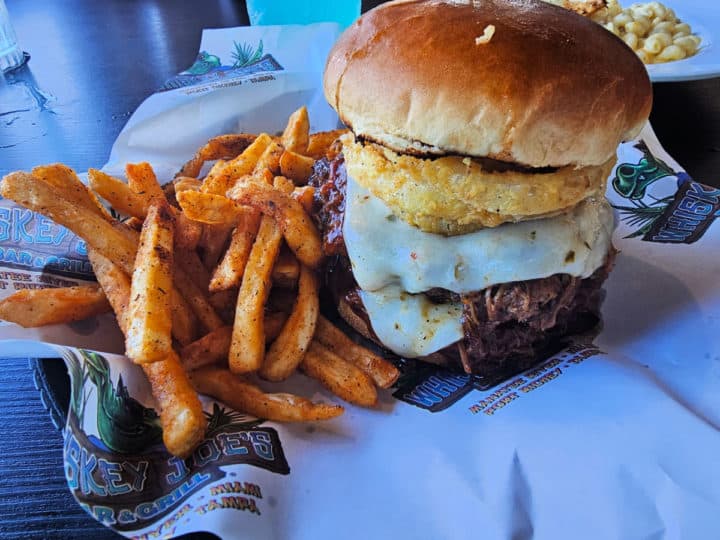 bbq burger loaded with cheese next to sweet potato fries