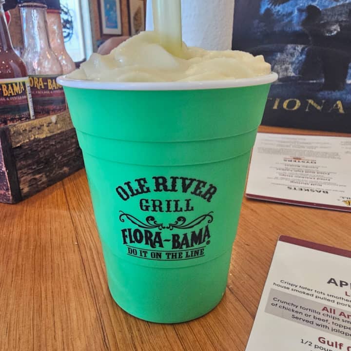 Bright green cup with Ole River Grill Flora-Bama Do it on the Line printed on it