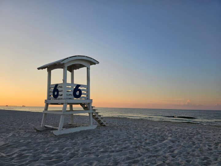 White lifeguard stand with sunrise and the gulf of Mexico in the background