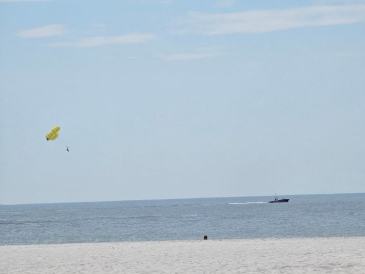 Boat pulling a parasailer viewed from the beach