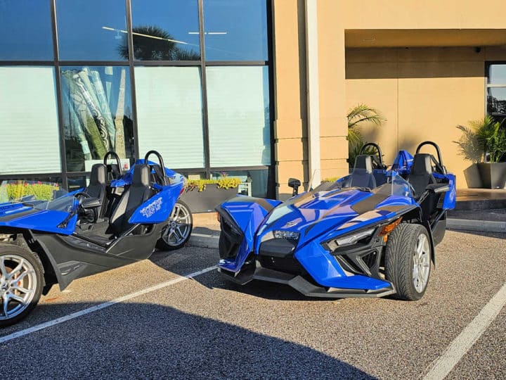 Blue Polaris Slingshot parked in a parking space