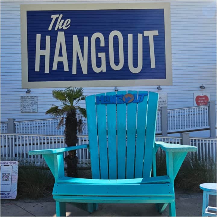 The Hangout sign over a giant blue Adirondack chair with The Hangout on it