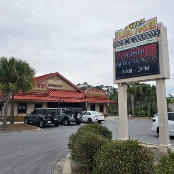 Andry's Flour Power Cafe & Bakery sign in a parking lot with the restaurant in the background