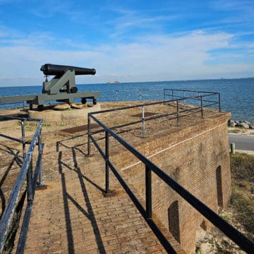 historic cannon on a brick fort looking out towards open water