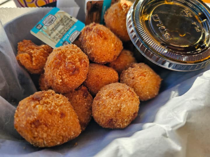 Hushpuppies in a basket with butter and sauce