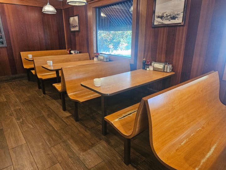 wooden booth benches and tables with pictures on the wall