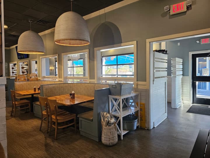 Indoor restaurant seating with a booth table with chairs at the end of it