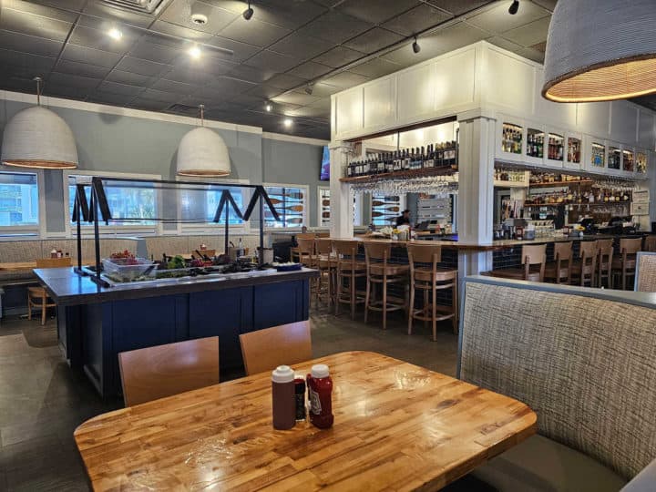 Indoor bar next to a salad bar and dining tables