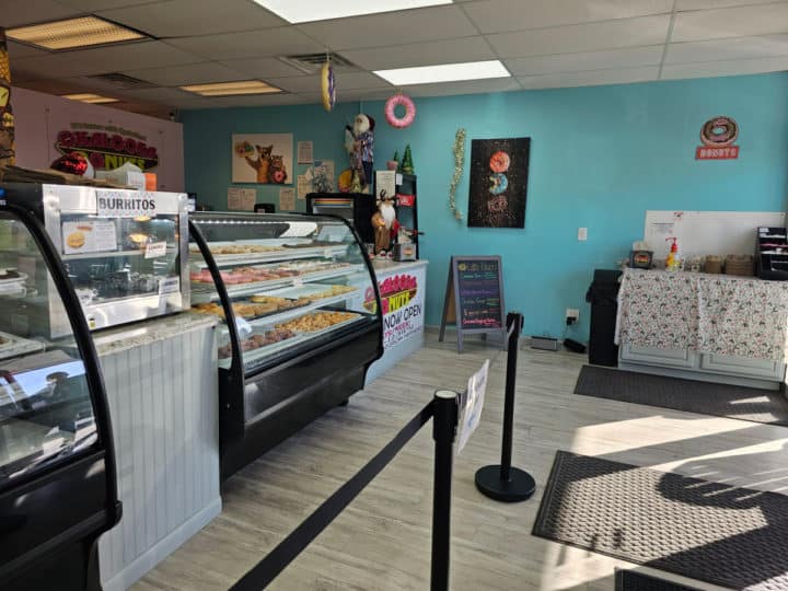 interior of bakery with bakery case, blue walls,and donut art