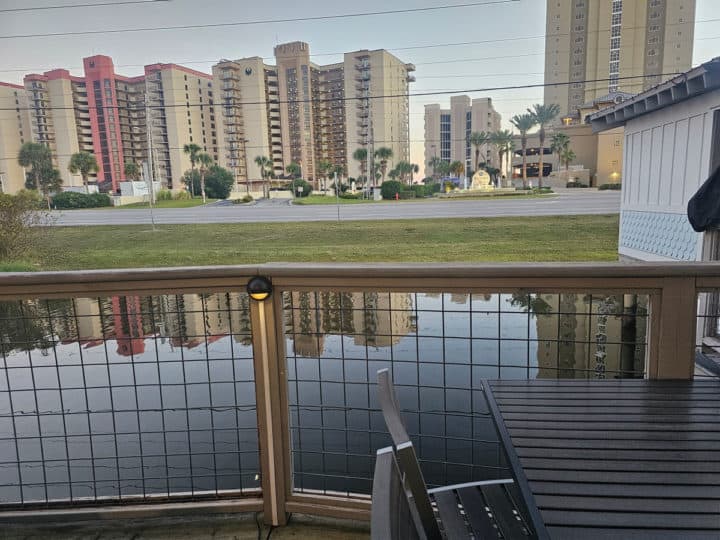 view from an outdoor deck of water and tall buildings on the other side of a large street