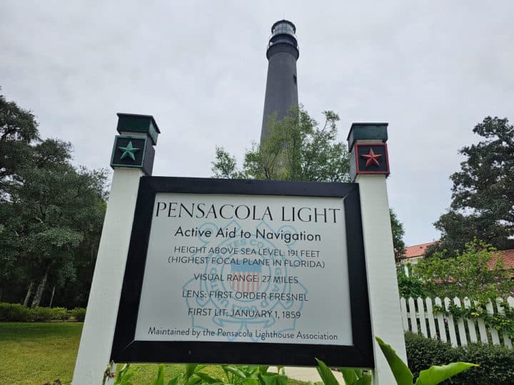 Pensacola Light information sign with the lighthouse in the background. 