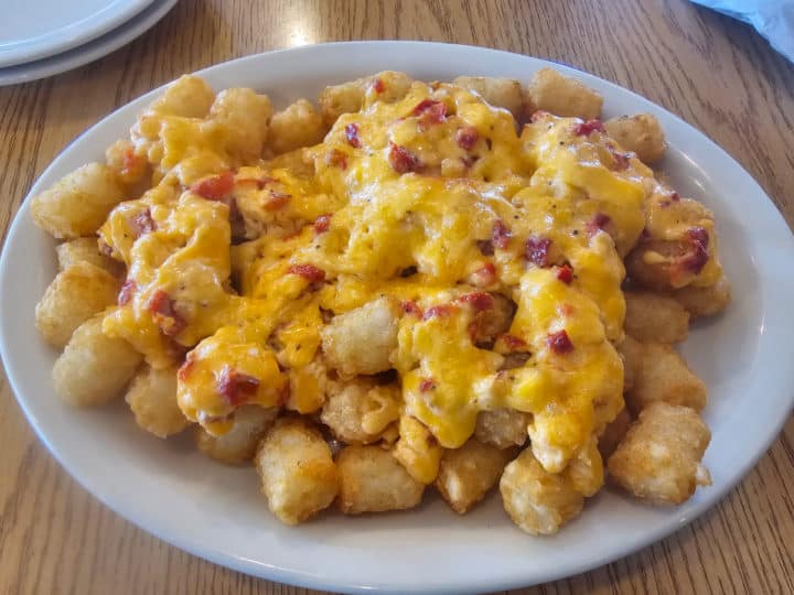 pimento cheese covered tater tots on a white plate