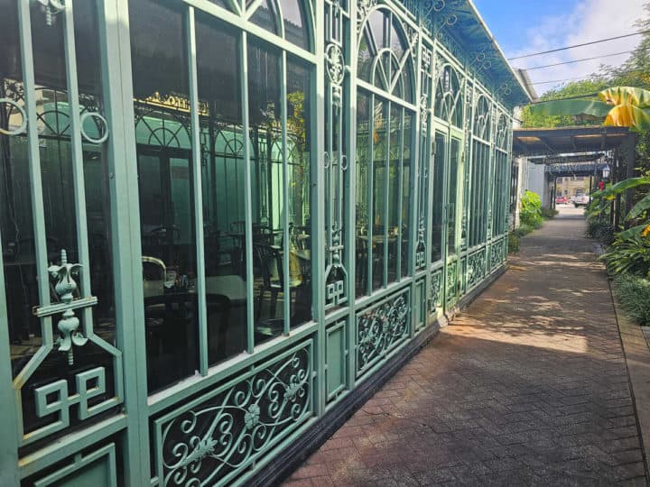 walkway past a solarium with plants along one side. 