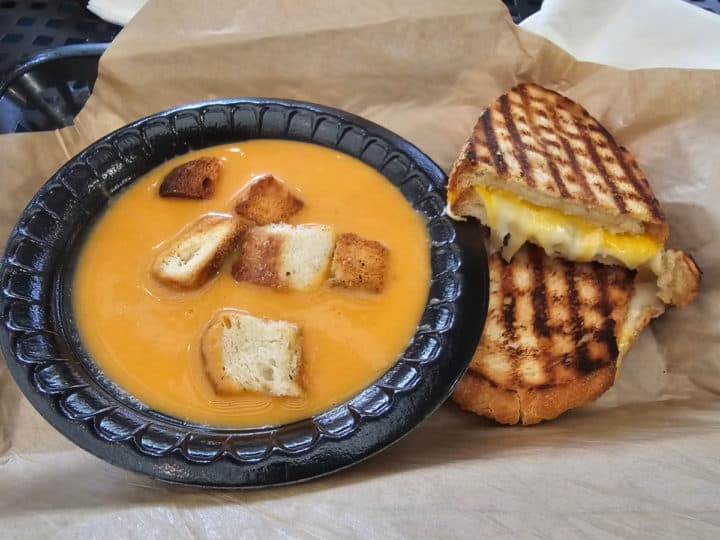 grilled cheese panini next to a bowl of soup