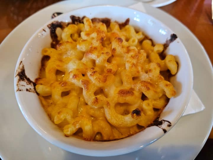 Baked macaroni and cheese in a white bowl on a white plate