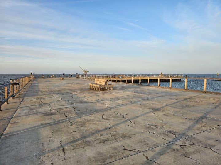 bench in the middle of the fishing pier