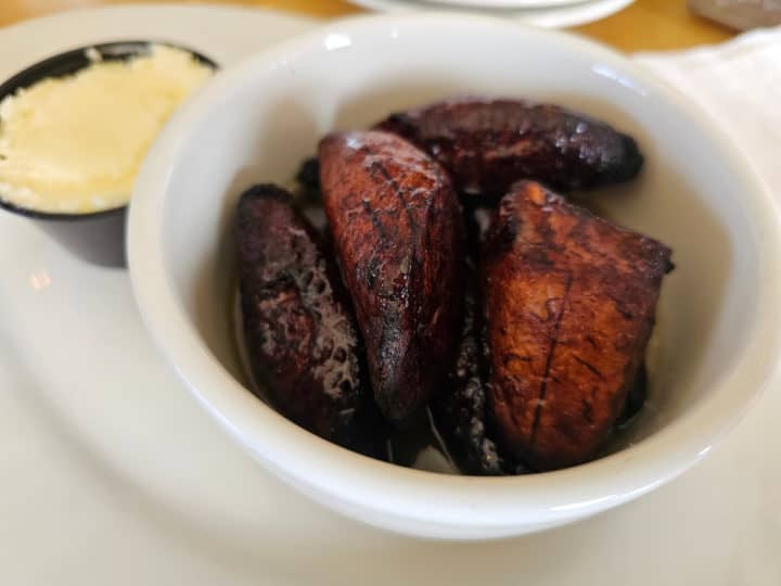 fried plantains in a white bowl next to cream cheese on a white plate