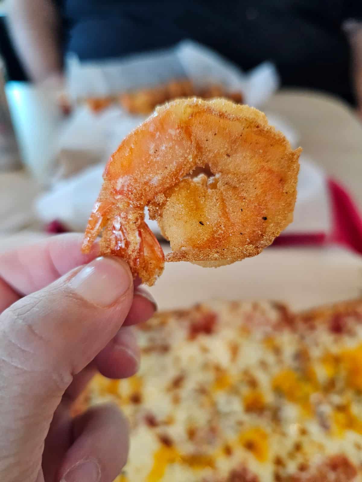 hand holding a perfectly fried shrimp