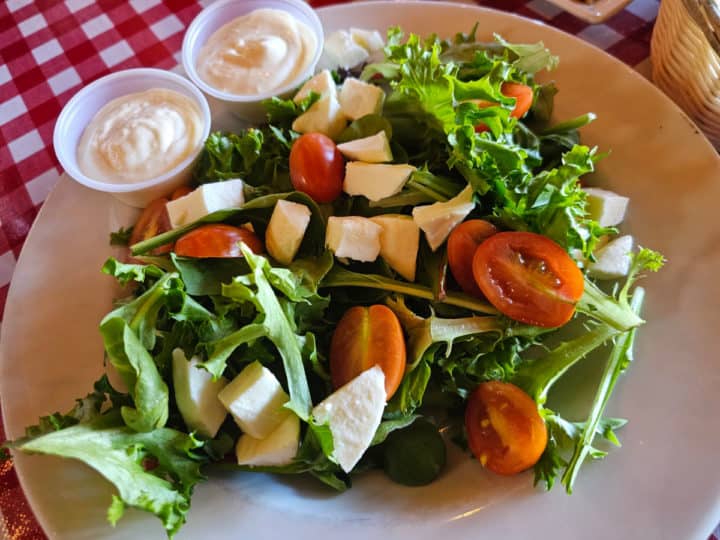 Salad with lettuce, tomatoes, and mozzarella on a white plate