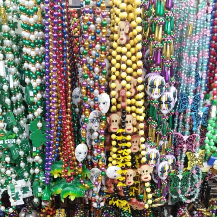 Colorful mardi gras beads hanging from hooks