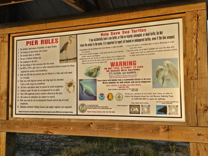 Pier rules and warning sign on a wooden board