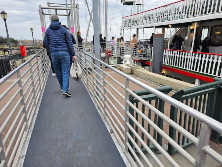 person walking up a ramp leading to a boat