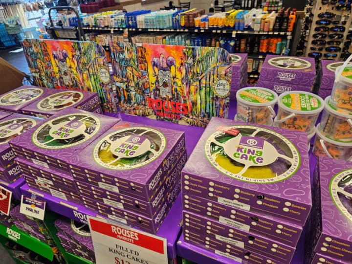 Table filled with purple Rouses King Cake Boxes and Mardi Gras cookies