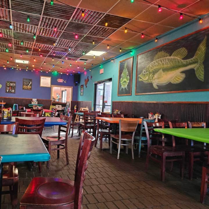 colorful restaurant with fish paintings on the wall and colorful lights