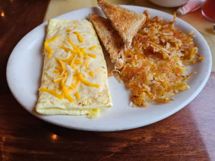 cheese omelet next to hashbrowns and toast