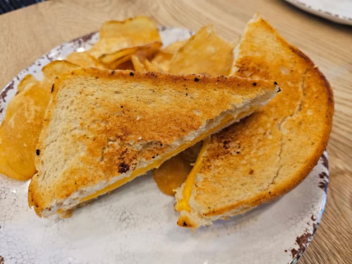 Grilled Cheese on a white plate with chips