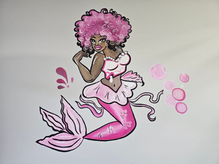 Black mermaid painting with pink hair, pink bikini top, and pink mermaid tail 