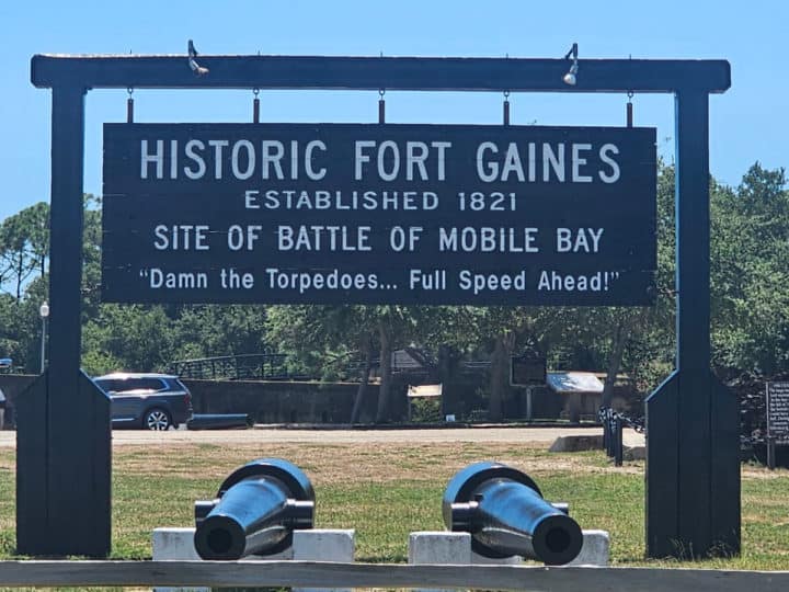 Historic Fort Gaines wooden sign over two cannons