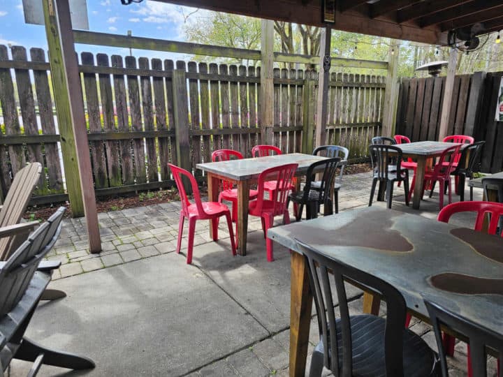 outdoor tables and chairs near a wooden fence