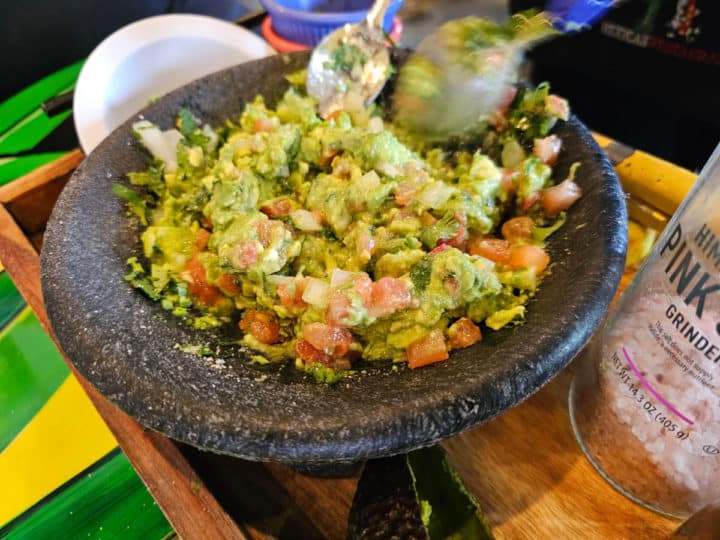 guacamole being prepared in a molcajete 