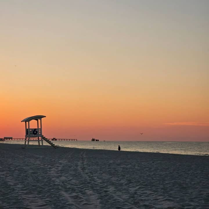 sunrise over a lifeguard stand on the beach