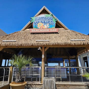 Bamboo Willie's Beachside Bar sign over a thatched roof and bar area