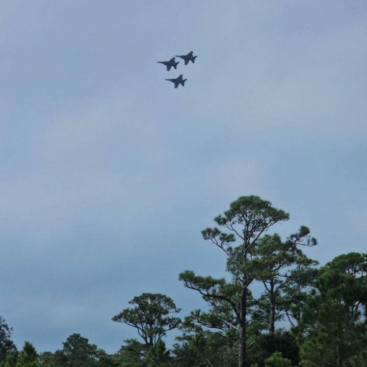 Three Blue Angels Jets fly over the tree tops at Fort Pickens