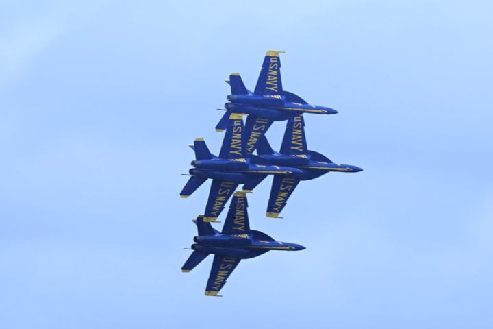 Four Blue Angels jets in a tight diamond pattern