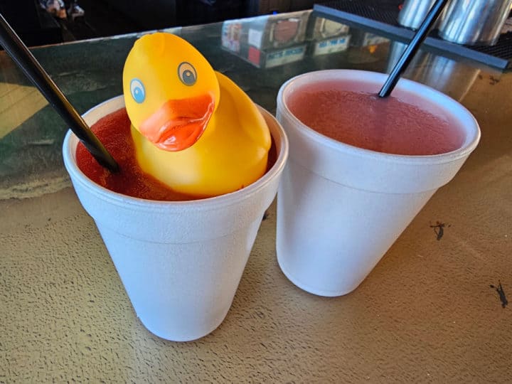 Frozen cocktails in Styrofoam cups with straws and a rubber ducky