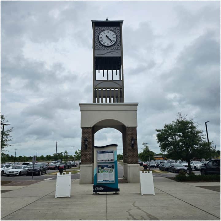 Clocktower with OWA Sign below it and parking lot in the background