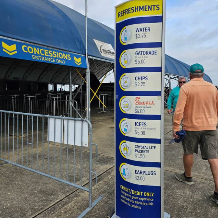 Concessions sign with prices and items next to a blue tent with Concessions Entrance Only sign