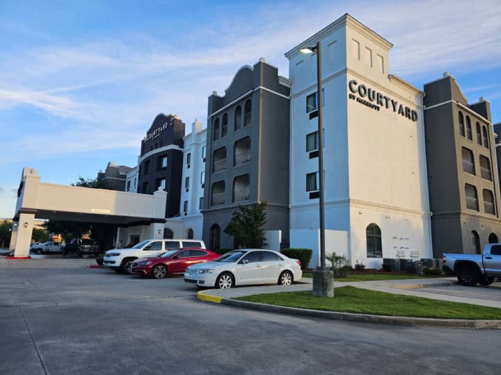 Multi-story Courtyard Marriott Hotel with cars parked in the parking lot