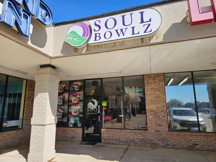 Soul Bowlz sign over a glass entrance door and windows in a shopping center